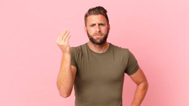 Genç yakışıklı adam kapiş ya da para hareketi yapıyor, sana ödemeni söylüyor.