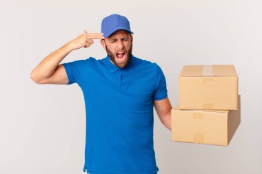 Genç yakışıklı adam mutsuz ve stresli görünüyor, intihar jesti silah işareti yapıyor. paket teslim kavramı