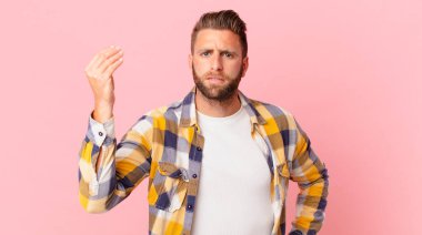 Genç yakışıklı adam kapiş ya da para hareketi yapıyor, sana ödemeni söylüyor.