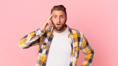 Genç yakışıklı adam şaşırmış görünüyor, yeni bir düşünce, fikir ya da konsept keşfediyor.