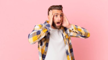 Genç yakışıklı adam mutlu, heyecanlı ve şaşırmış hissediyor.