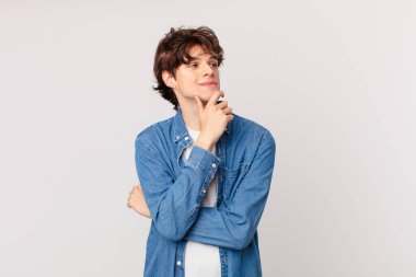 Genç yakışıklı adam mutlu bir şekilde gülümsüyor ve hayal kuruyor.