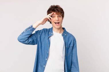 Genç yakışıklı adam mutlu, şaşkın ve şaşkın görünüyor.