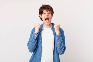 Genç yakışıklı adam sinirli bir ifadeyle agresif bir şekilde bağırıyor.