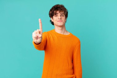 Genç yakışıklı adam gülümsüyor ve arkadaş canlısı görünüyor.