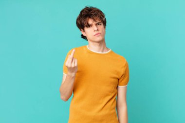 Genç ve yakışıklı adam sinirli, sinirli, asi ve agresif hissediyor.