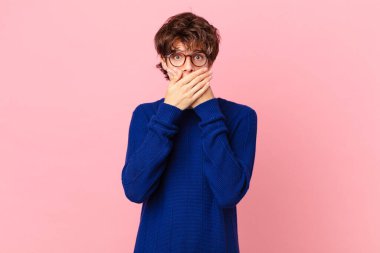 Genç ve yakışıklı bir adam elleri ile ağzını kapatıyor.