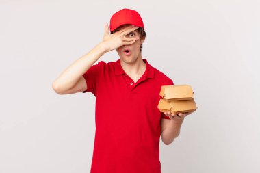 Hamburger dağıtan adam şok olmuş, korkmuş ya da korkmuş görünüyor.