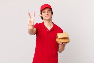 Hamburgerci adam gülümsüyor ve arkadaş canlısı görünüyor.