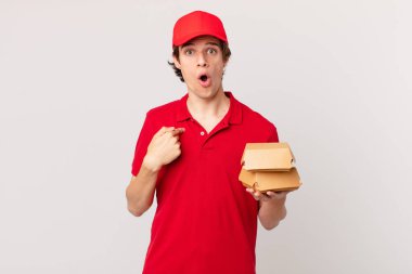 Hamburger dağıtan adam şok olmuş ve ağzı açık, kendini işaret ederek şaşırmış görünüyor.