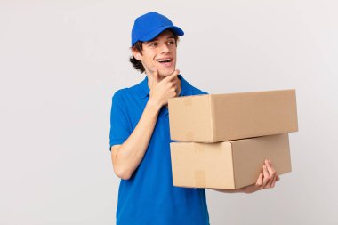 Paket teslim adam mutlu, kendinden emin bir ifade ile gülümseyerek çene üzerinde elle