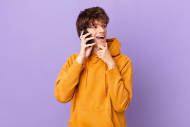 Bir hücreyi tutan genç adam mutlu ve kendinden emin bir ifadeyle gülümsüyor.