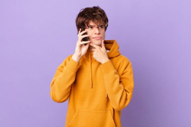 Genç adam bir hücrede düşünüyor, kuşkulu ve şaşkın hissediyor.