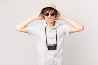 Genç gezgin ya da turist stresli, endişeli ya da korkmuş, elleri başının üstünde.