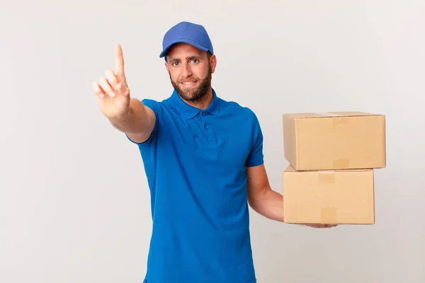 Jonge Knappe Man Glimlachend Vriendelijk Toont Nummer Één Pakket Leveren — Stockfoto