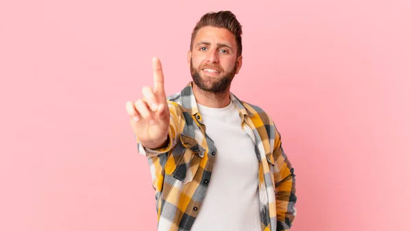 Joven Hombre Guapo Sonriendo Orgullosamente Con Confianza Haciendo Número Uno —  Fotos de Stock