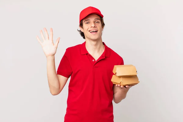 Burger Deliver Man Smiling Happily Waving Hand Welcoming Greeting You — Stock Photo, Image