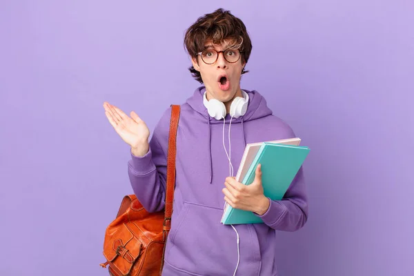 Young Student Man Looking Surprised Shocked Jaw Dropped Holding Object — Fotografia de Stock