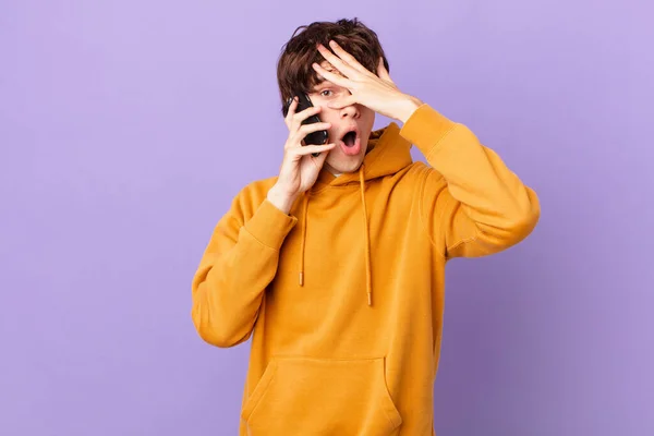 Młody Człowiek Trzymający Celę Wyglądającą Zszokowaną Przerażoną Lub Przerażoną Zakrywającą — Zdjęcie stockowe