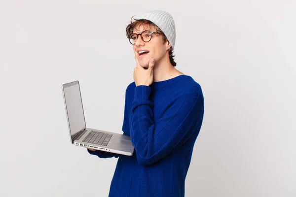 Jovem Com Laptop Sorrindo Feliz Sonhando Acordado Duvidando — Fotografia de Stock