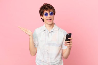 Cep telefonlu genç adam kendini mutlu hissediyor, bir çözüm ya da fikir bulduğuna şaşırıyor.