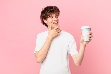 Kahveli genç adam mutlu bir şekilde gülümsüyor ve hayal kuruyor.