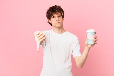 Kahveli genç adam haç hissediyor, baş parmağını kaldırıyor.