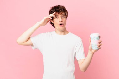 Kahveli genç adam mutlu, şaşkın ve şaşkın görünüyor.