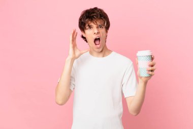 Kahveli genç adam ellerini havaya kaldırarak çığlık atıyor.