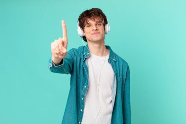 Kulaklıklı genç adam gülümsüyor ve arkadaş canlısı görünüyor.