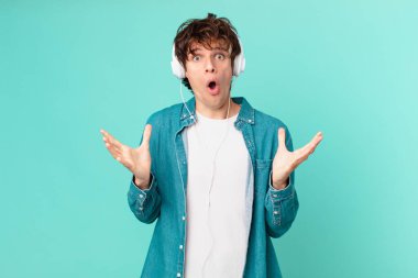 Kulaklıklı genç adam şok olmuş ve şaşırmış hissediyor.