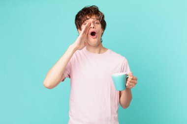 Elinde kahve fincanı olan genç adam kendini mutlu hissediyordu. Elleri ağzının kenarında bağırıyordu.