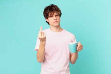 Elinde kahve fincanı olan genç adam kızgın, sinirli, asi ve agresif hissediyor.