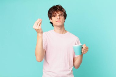 Elinde kahve fincanı olan genç bir adam kapiş ya da para hareketi yapıyor, sana ödemeni söylüyor.