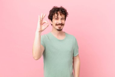 Genç yakışıklı adam kendini mutlu hissediyor, onayını veriyor.