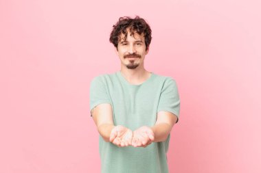 Genç yakışıklı adam mutlu bir şekilde gülümsüyor.