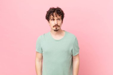 Genç ve yakışıklı bir adam üzgün, üzgün ya da kızgın hissediyor.