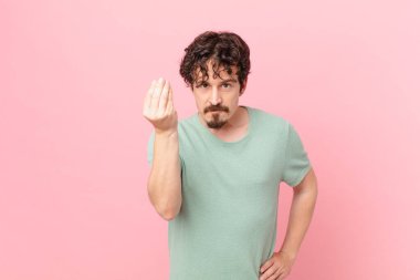 Genç yakışıklı adam kapiş ya da para hareketi yapıyor, sana ödemeni söylüyor.