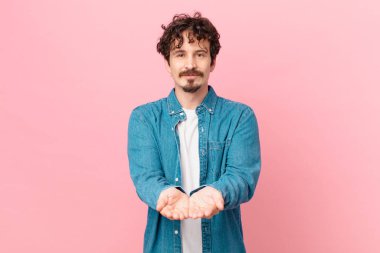 Genç yakışıklı adam mutlu bir şekilde gülümsüyor.