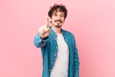 Genç yakışıklı adam gururla gülümsüyor ve kendinden emin bir numara oluyor.