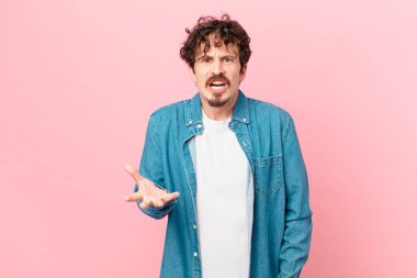 Genç yakışıklı adam sinirli, sinirli ve sinirli görünüyor.