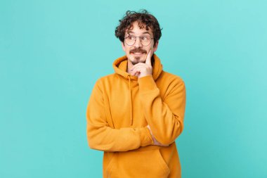 Genç yakışıklı adam mutlu bir şekilde gülümsüyor ve hayal kuruyor.