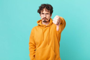 Genç ve yakışıklı adam kendini kötü hissediyor, baş parmağını kaldırıyor.