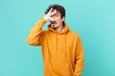 Genç yakışıklı adam şok olmuş, korkmuş ya da korkmuş görünüyor.