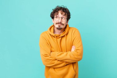 Genç yakışıklı adam omuz silkiyor, kafası karışık ve kararsız.