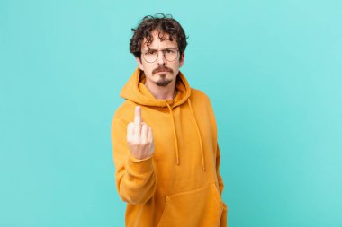 Genç ve yakışıklı adam sinirli, sinirli, asi ve agresif hissediyor.