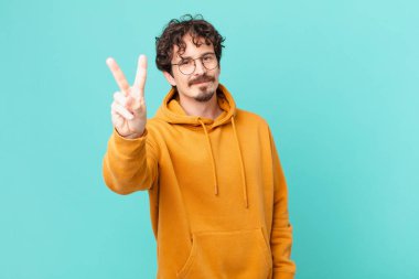 Genç yakışıklı adam gülümsüyor ve arkadaş canlısı görünüyor.