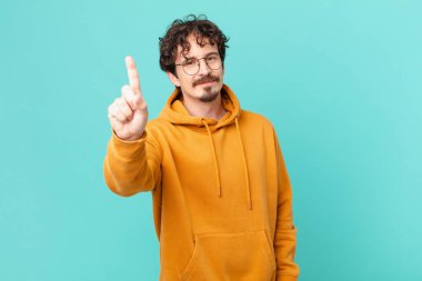 Genç yakışıklı adam gülümsüyor ve arkadaş canlısı görünüyor.