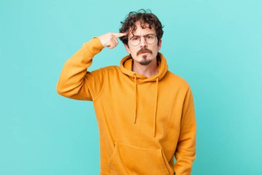 Genç yakışıklı adam kafası karışık ve şaşkın hissediyor, deli olduğunu gösteriyor.