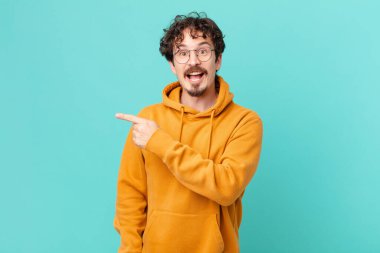 Genç yakışıklı adam heyecanlı ve şaşırmış görünüyor.